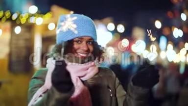 快乐的黑人女孩在圣诞庆典上与火花舞